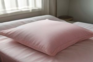 Blush pink silk pillowcase on a bed